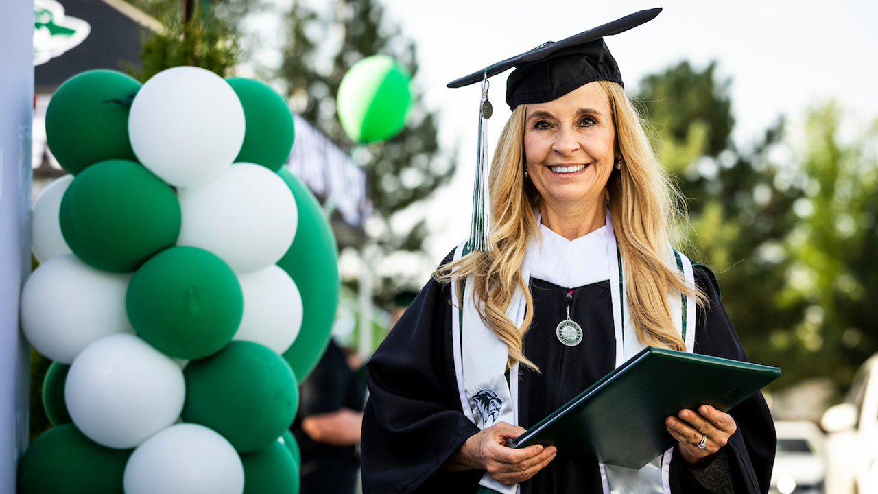 A graduate posing with her degree